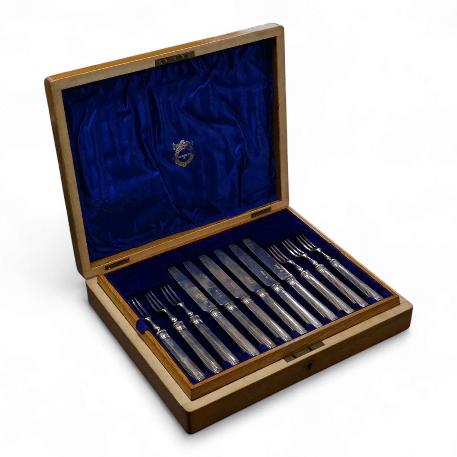 A set of twelve pairs of silver dessert eaters, by Thomas Bradbury & Sons, London, 1913, knife 19.8cm, handles loaded, housed in a fitted oak canteen.